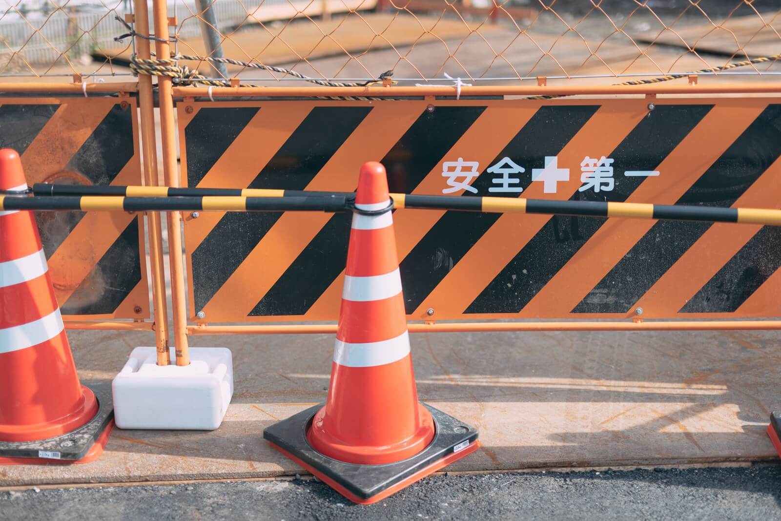 スライドショー2枚目、工事現場のフェンス近くにある三角コーン