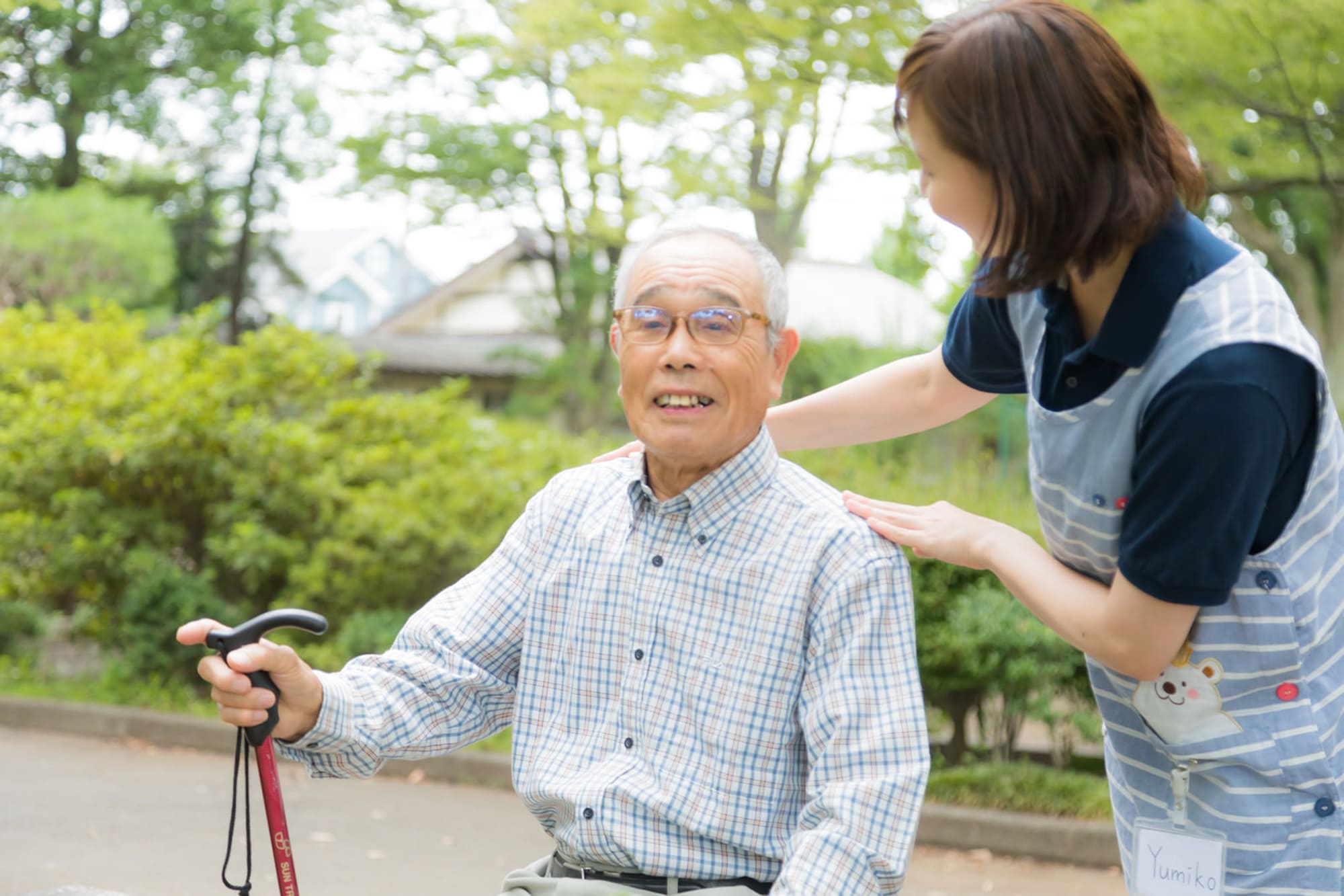 笑顔の男性と介護士が外に出て楽しそうに話している様子
